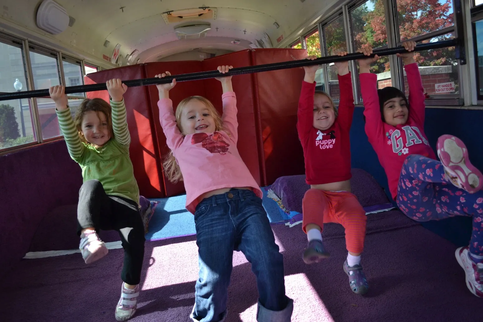 kids hanging on a bar